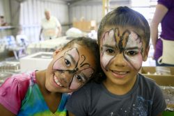 Two smiling girls show off their newly painted faces.