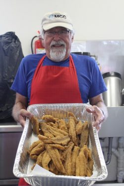 Sam Miller holding freshly fried fish.