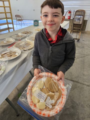 Child holding plate of cookies