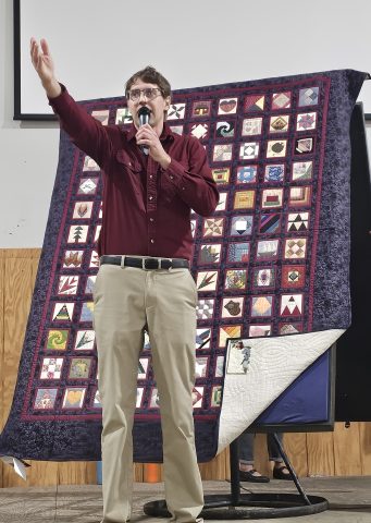 Auctioneer selling a quilt